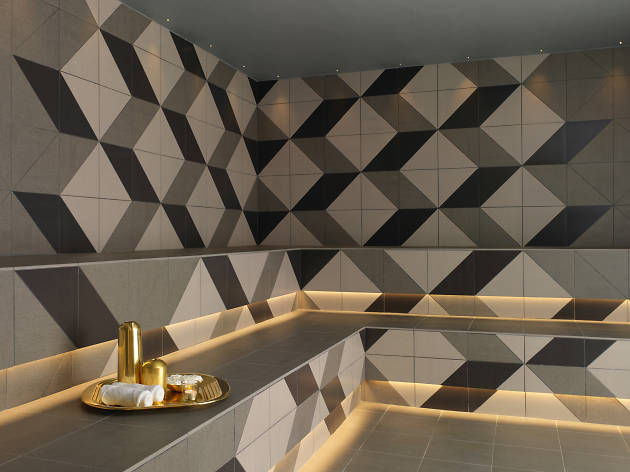 Modern spa interior with geometric wall tiles, ambient lighting, and luxurious decor at Agua Spa in London.