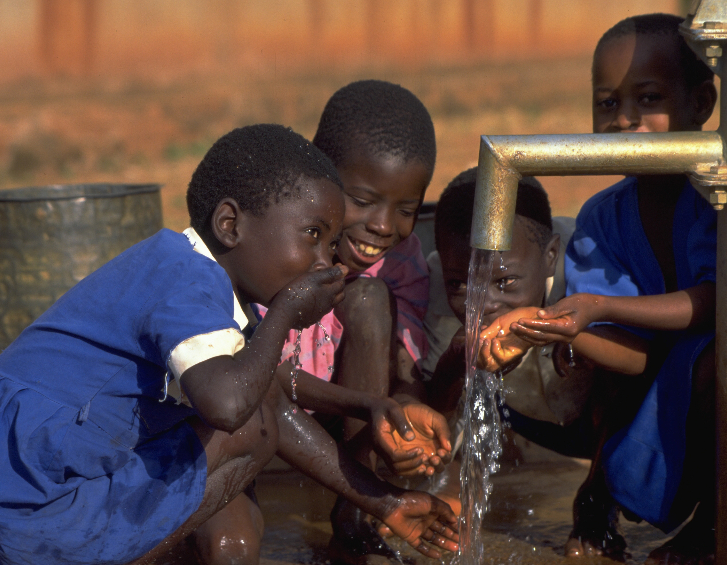Children in Zambia drinking clean water, showcasing a community project.