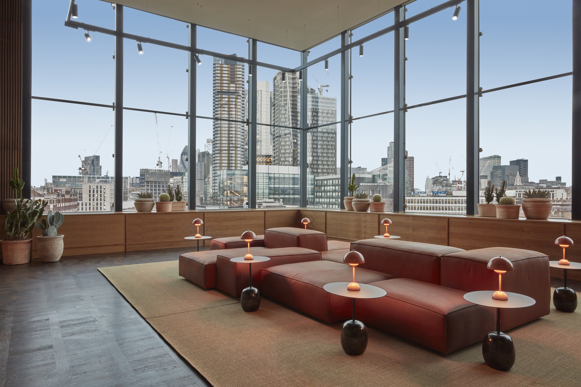 A spacious hotel lobby with expansive windows showcases a stunning view of the bustling city outside.