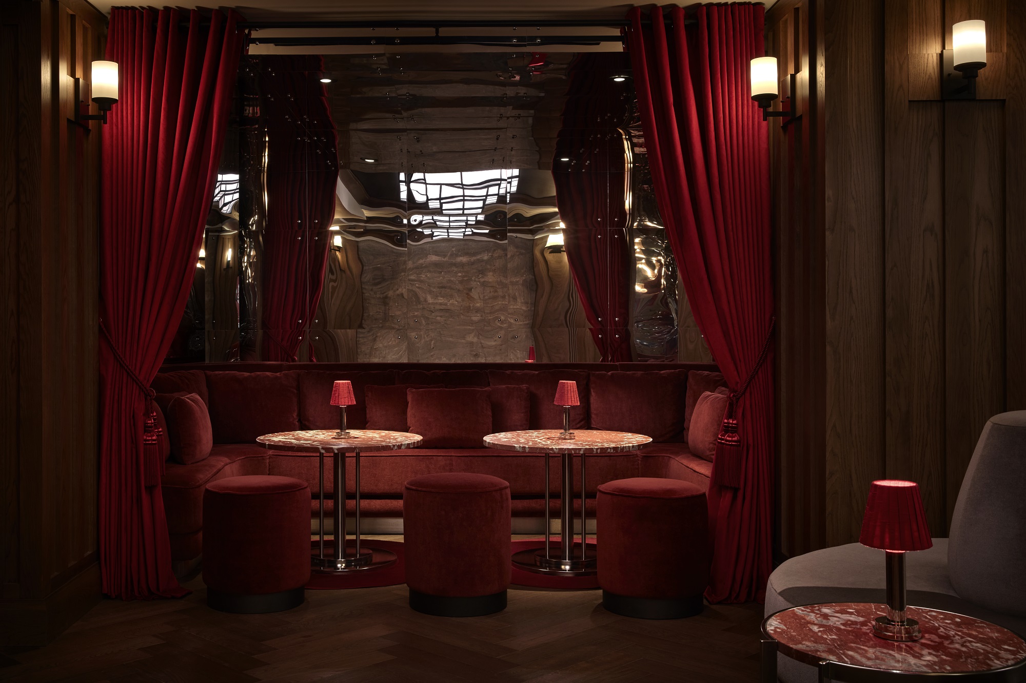 A trendy bar with a long marble counter, modern seating, and vibrant decor.