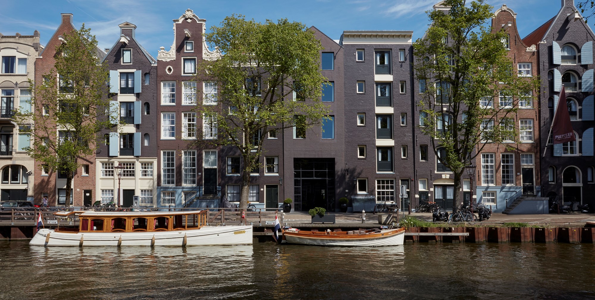 A scenic view of buildings lining the water's edge, with several boats gently floating nearby.