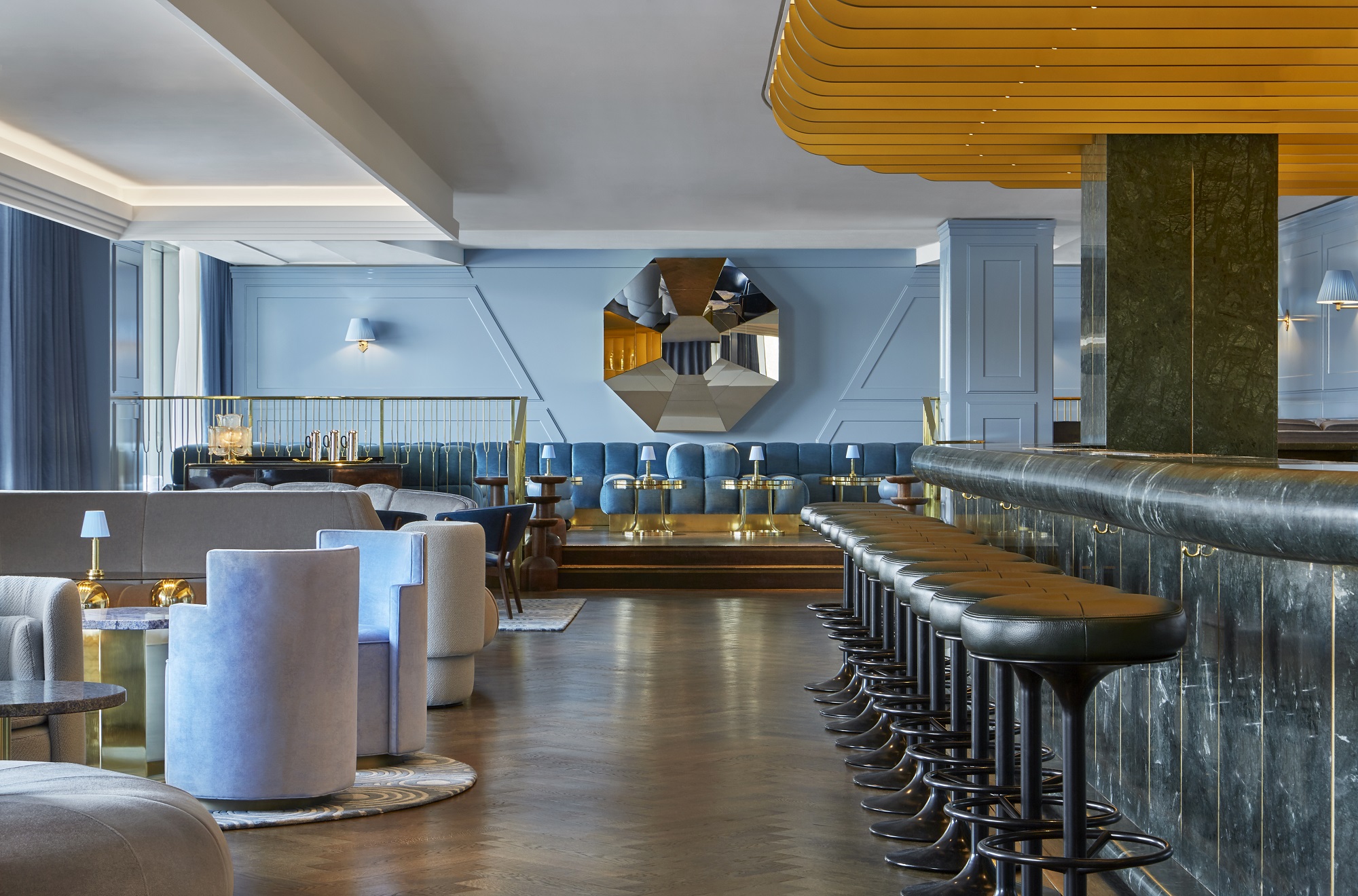 A trendy bar with a long marble counter, modern seating, and vibrant decor.