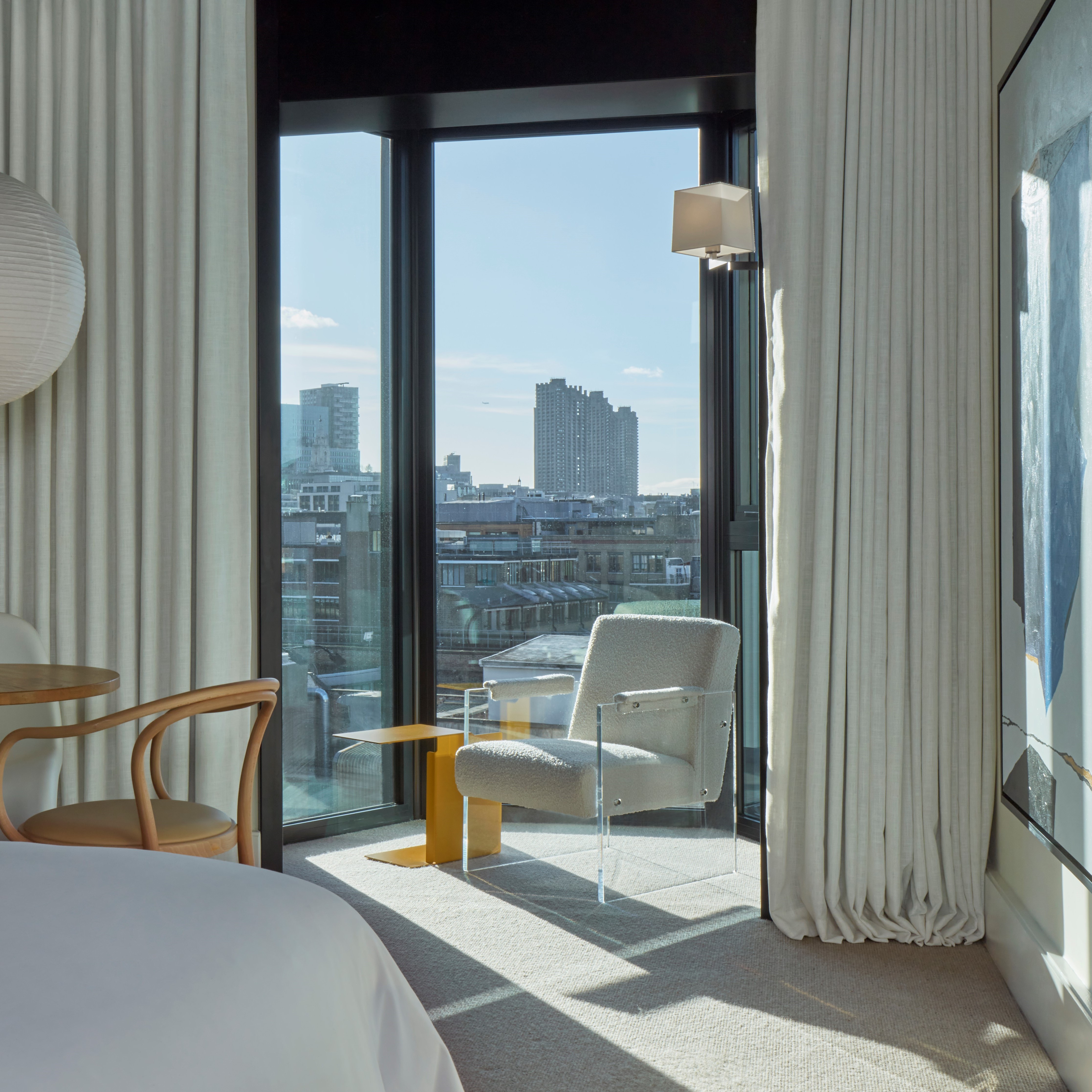 A spacious room with modern furnishings, large windows, and a serene, neutral color palette.