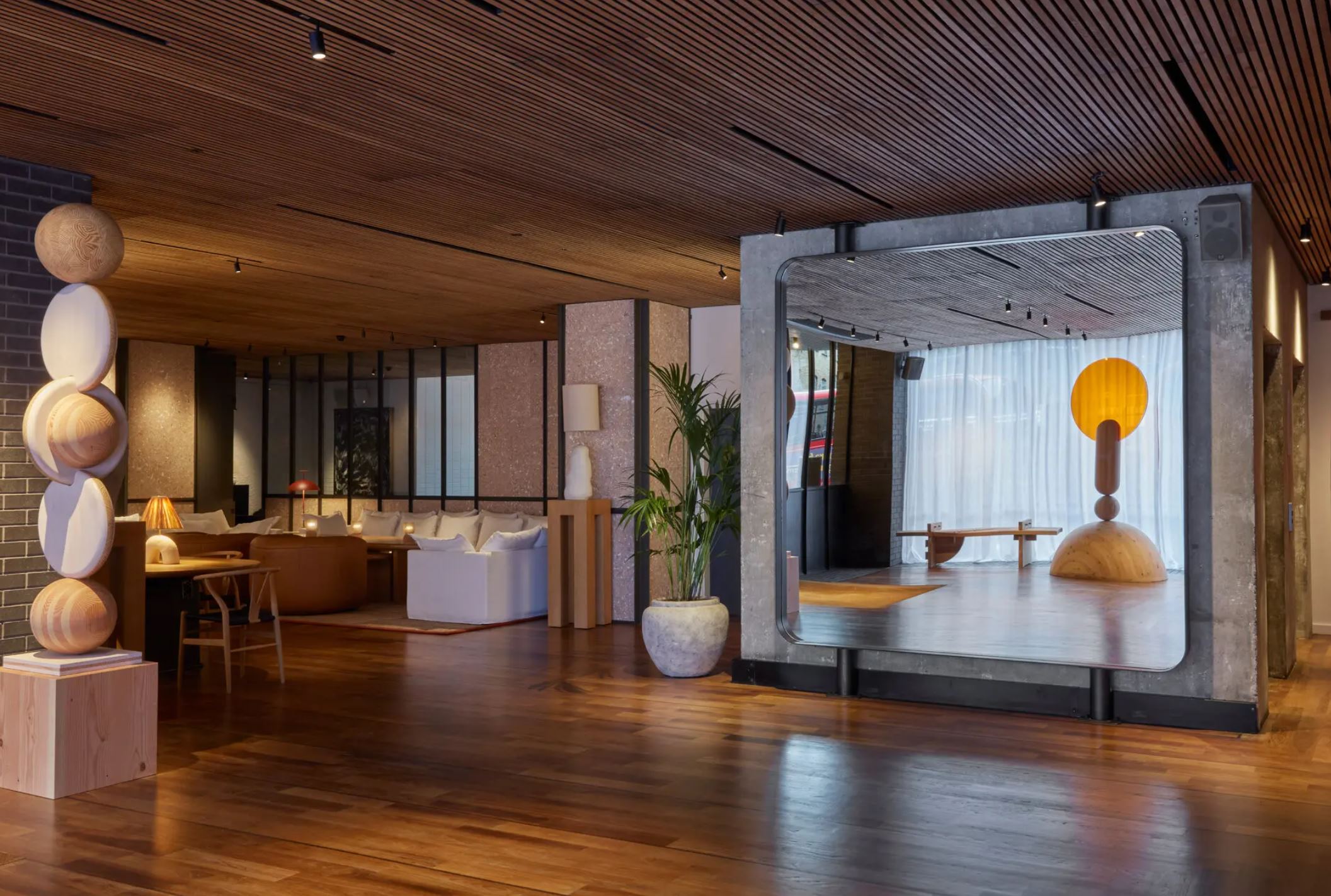 A hotel lobby featuring elegant wooden floors and a large decorative mirror, creating a welcoming atmosphere for guests.