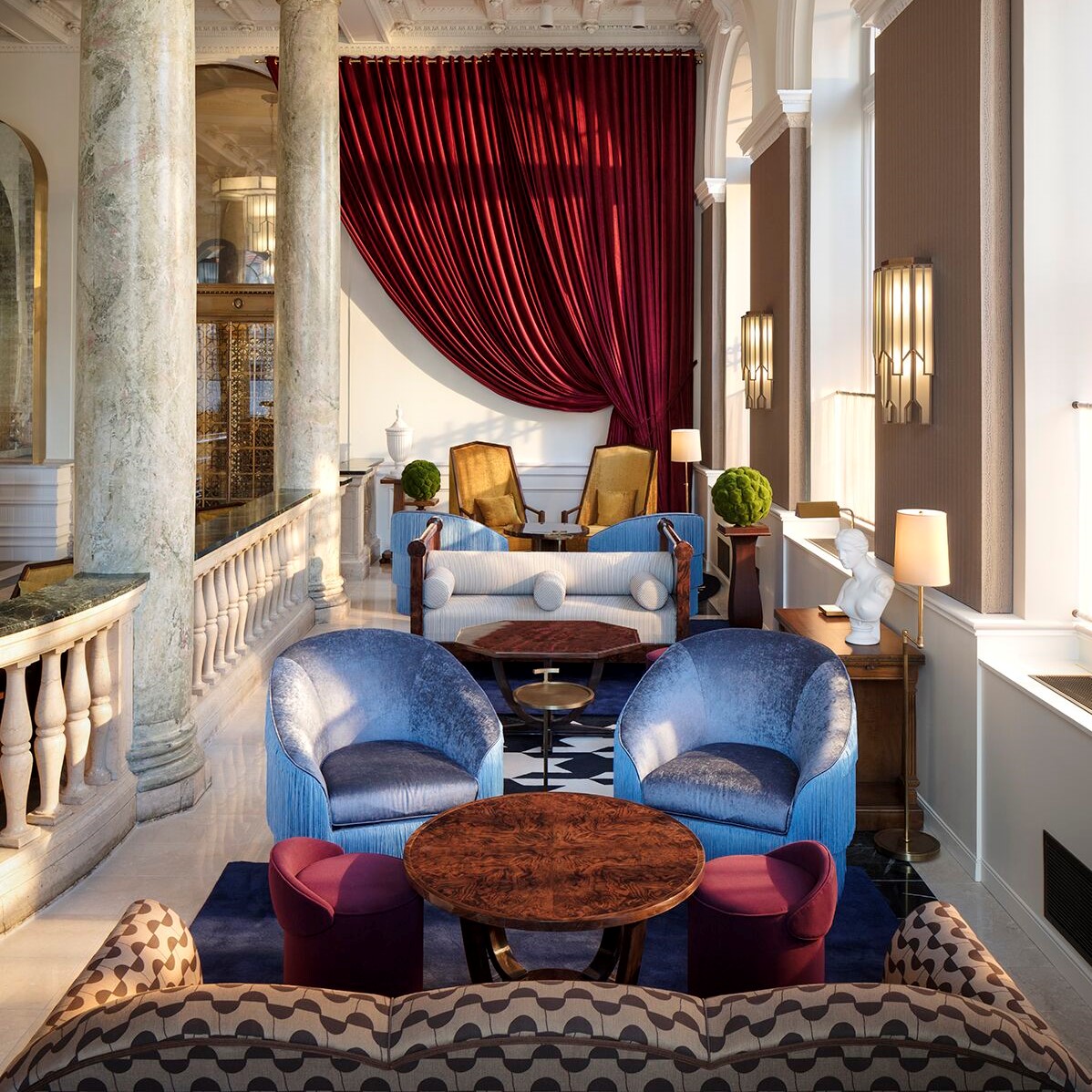 Luxurious hotel lounge with rich velvet curtains, elegant seating, and a blend of classic and contemporary decor.