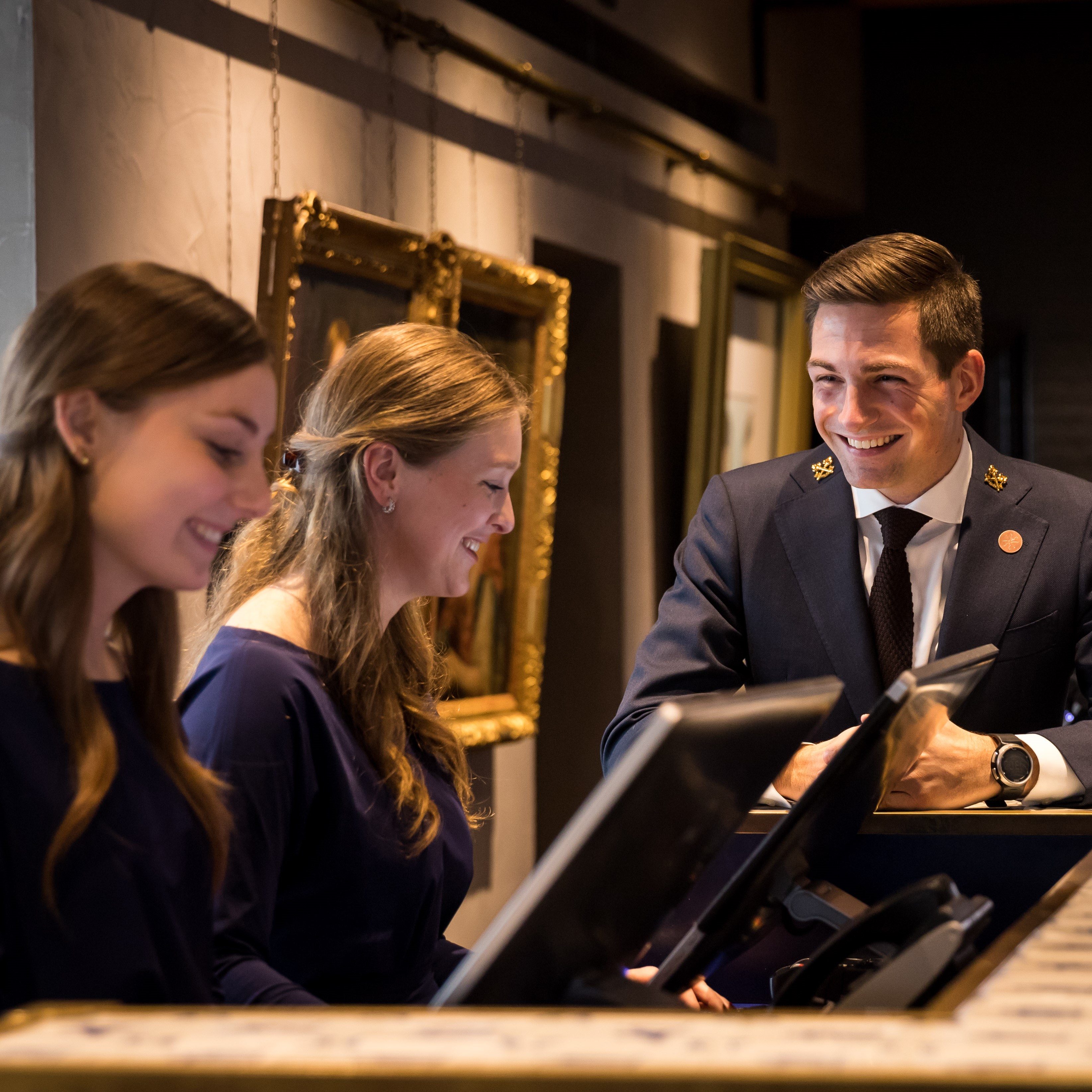 Recruitment photo shoot at Pulitzer Amsterdam, showcasing three staff members with warm smiles.