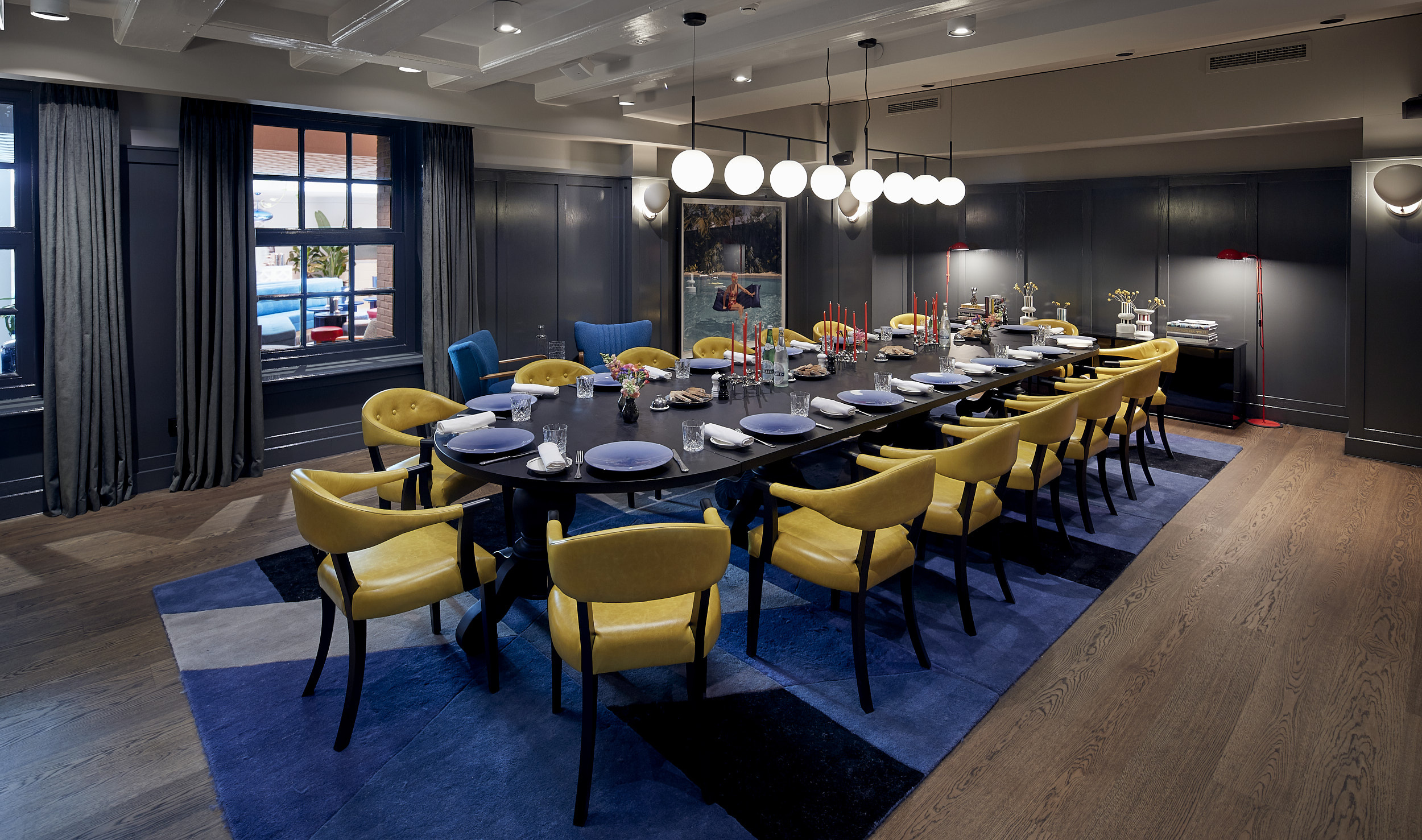 A private dining room with a long table, luxurious chairs, and warm ambient lighting, creating an intimate setting.
