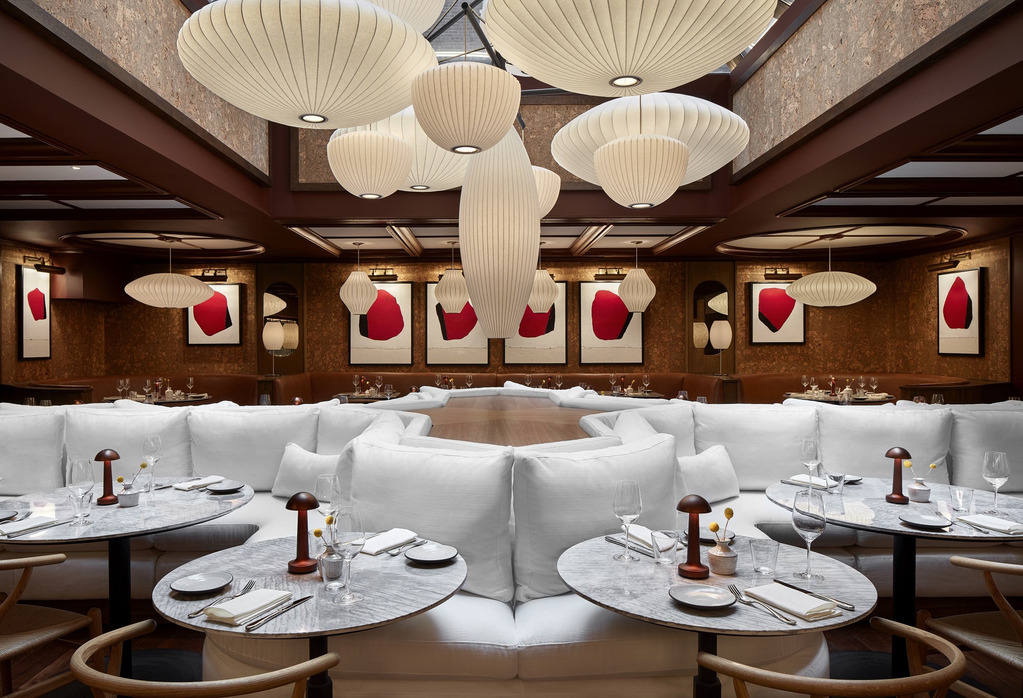 An upscale dining establishment showcasing white furniture and large, stylish lamps that enhance the ambiance.